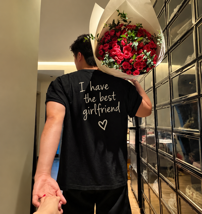 Mann mit Rosenstrauß trägt ein mit ShirtUp! personalisiertes T-Shirt mit der Aufschrift „I have the best girlfriend“.